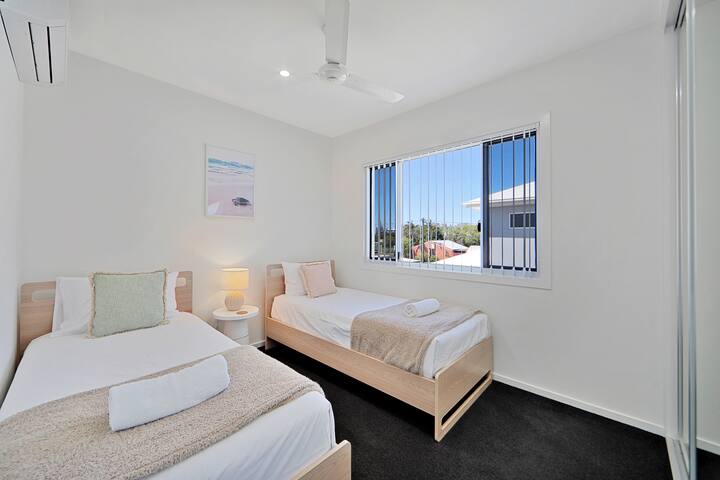 Sovrum med två enkelsängar, takfläkt och luftkonditionering