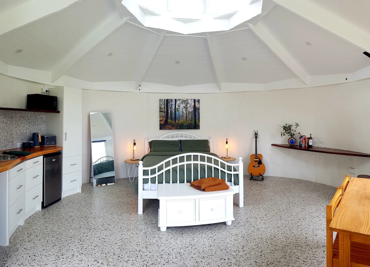 室内空间；小厨房、标准双人床、冲浪板长凳、餐桌 