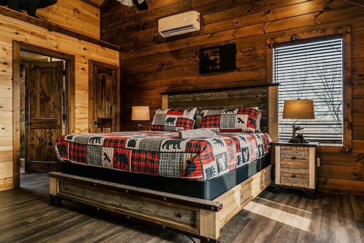 Upstairs king bedroom with smart TV, private deck, and en suite bathroom with tile shower and soaker tub. 