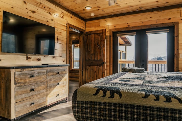 Downstairs king bedroom with en suite bathroom, smart TV, and private deck. 