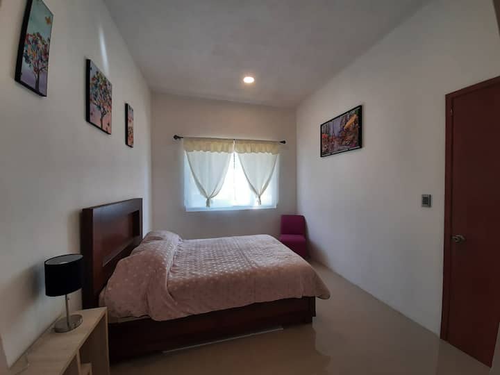 Priestranná, svetlá izba s manželskou posteľou a oknom, ktoré poskytuje dobré prirodzené osvetlenie.