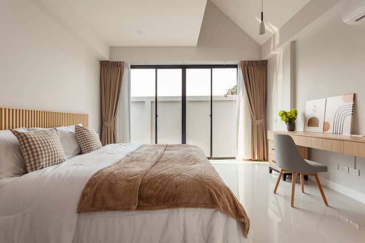 غرفة النوم الثانية على جانب المنزل مع سقف مرتفع وسقف متدرج. 