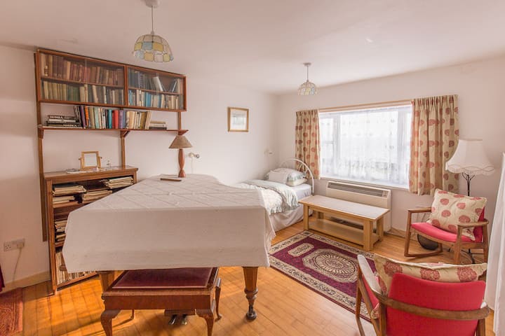 downstairs bedroom/music room, with two singles beds and Bachstein small grand piano