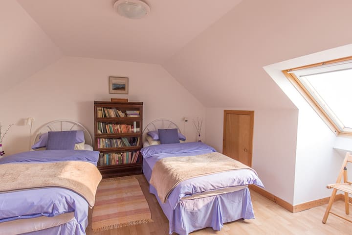 Upstairs bedroom with twin beds, and skylight facing sea