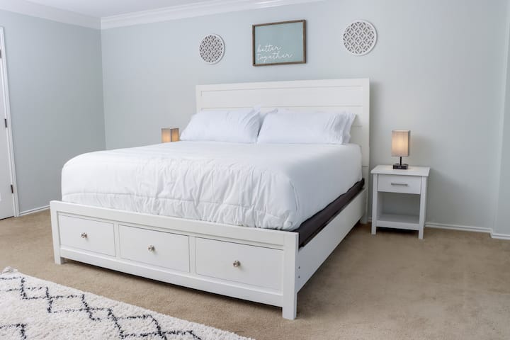Nuestro dormitorio principal 1, con un colchón de espuma viscoelástica Beautyrest tamaño king. Disfruta de la comodidad adicional de las lámparas de carga USB del teléfono, el almacenamiento debajo de la cama, una cómoda, un vestidor del tamaño de Texas y un baño.