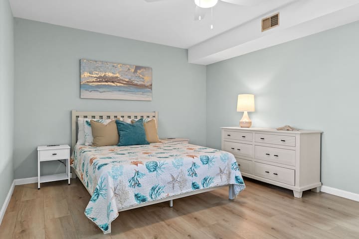 Спална соба на долниот кат 2 опремена со брачен кревет, гардеробер и ноќни шкафчиња.