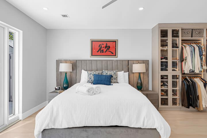 Dormitorio principal con armario diseñado a medida y puertas francesas al patio trasero exterior.