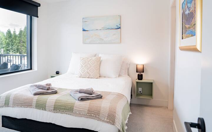 Hoofdslaapkamer met ensuite-badkamer en uitzicht op de bergen. 