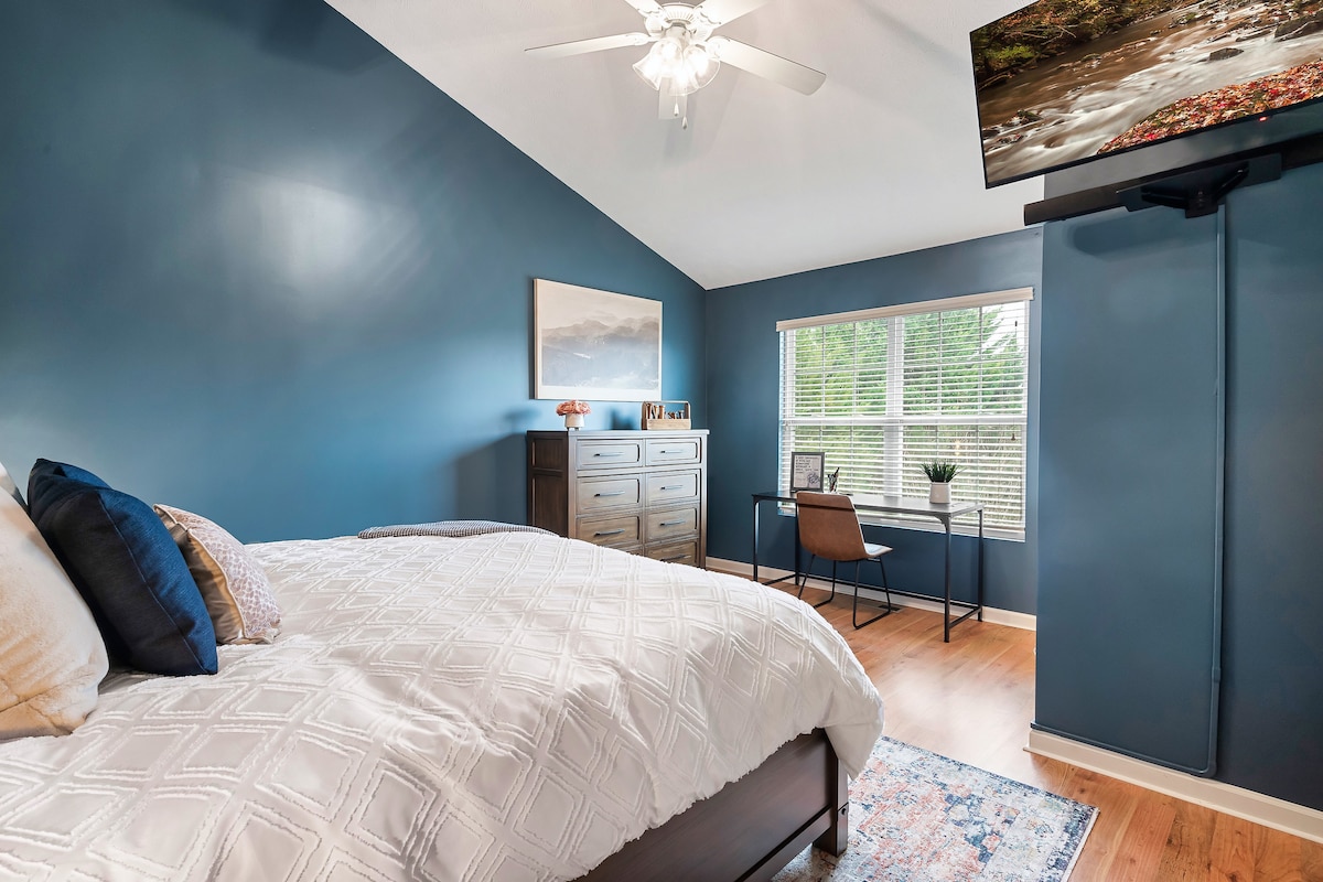 Dhomë gjumi e madhe kryesore, me tavane katedrale dhe mobilie të larta.  