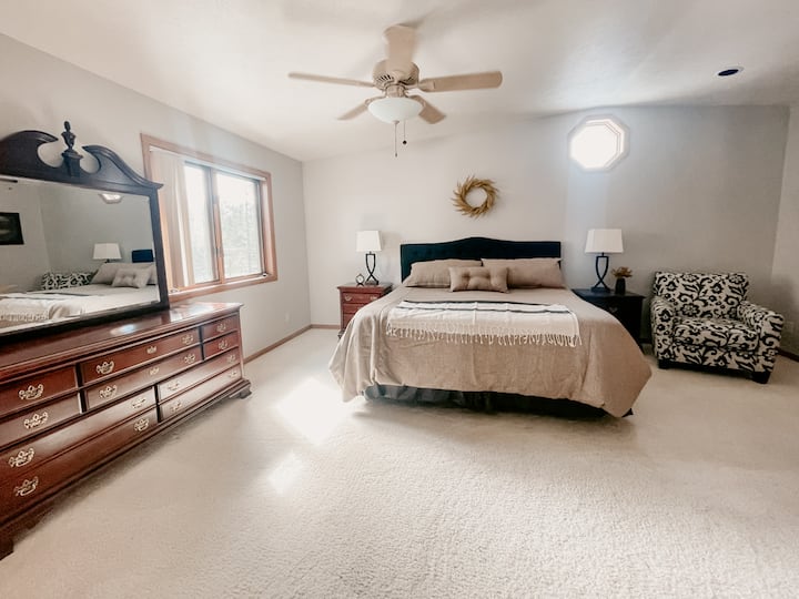 Master suite with a king bed, dresser, bedside tables, french doors, large closet, seating area, and master bathroom