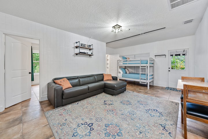 This is Living Area #3 and is located in the mother-in-law suite. There is a projector TV aiming at the wall to right. Also a queen sleeper sofa, bathroom, exterior door that goes to side yard and outdoor shower, queen bedroom to the left.