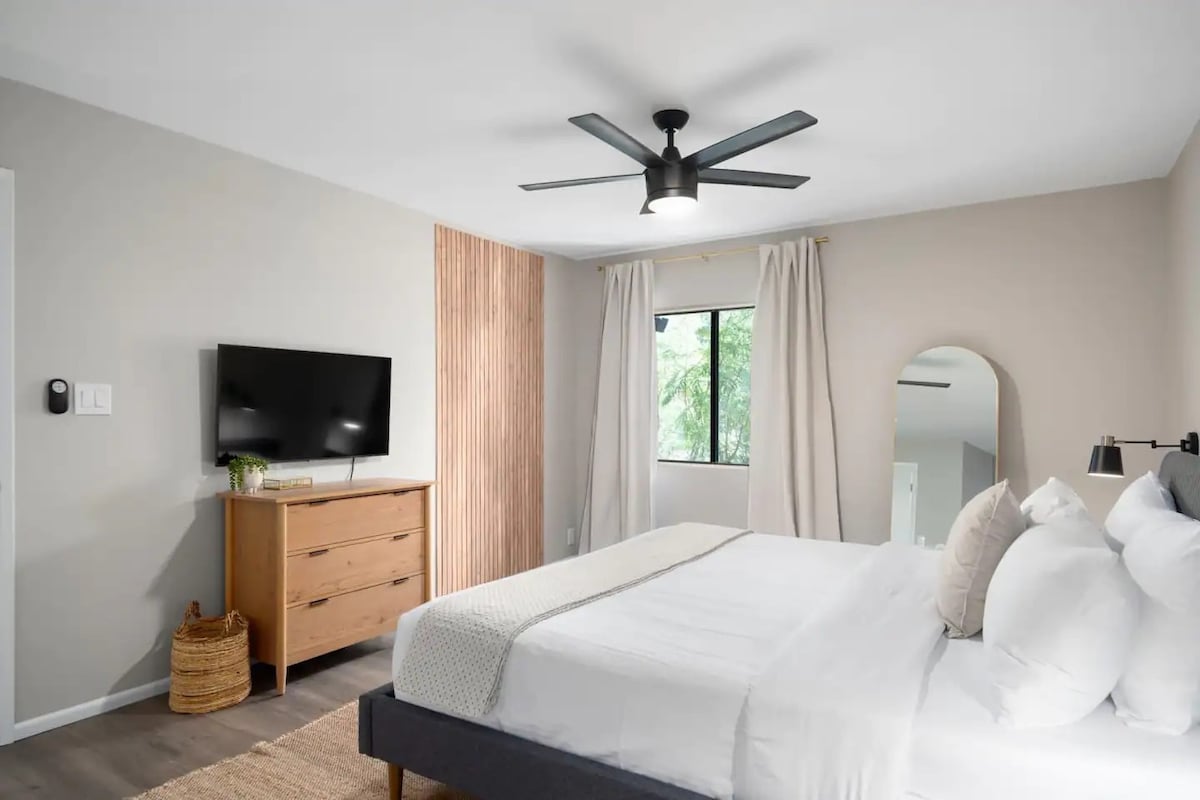 A stylish and spacious primary bedroom with 4K Smart TV.