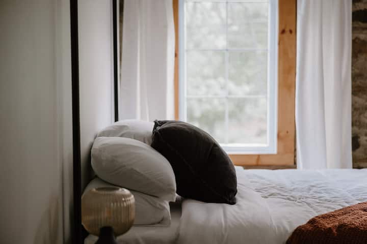 Тази уютна спалня разполага с луксозно двойно легло, оборудвано с плюшени възглавници и меко спално бельо за спокоен нощен сън. В стаята има и малко бюро, идеално за наваксване на работа или сърфиране в мрежата.