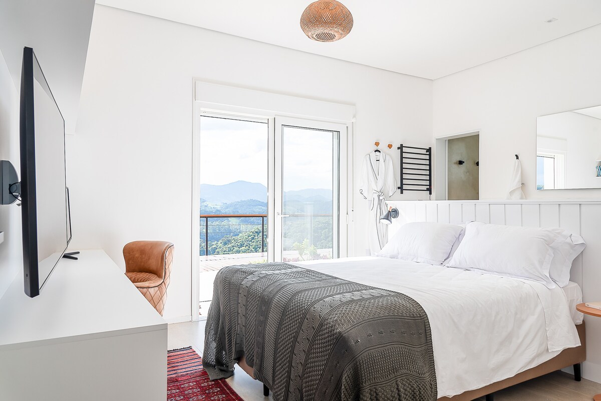 Აპარტამენტი 1 - ხედი მთებზე, ზეთისხილის ჭალებსა და გორაკებზე, დედოფლის ზომის საწოლი, 25 მ2 სუფთა კომფორტი. Აბაზანის, უნიტაზისა და ნიჟარის სამუშაო ზედაპირები და სარკეები ცალკე ოთახებში უზრუნველყოფს იდეალურ ჰიგიენას, კეთილდღეობასა და განმარტოებას.