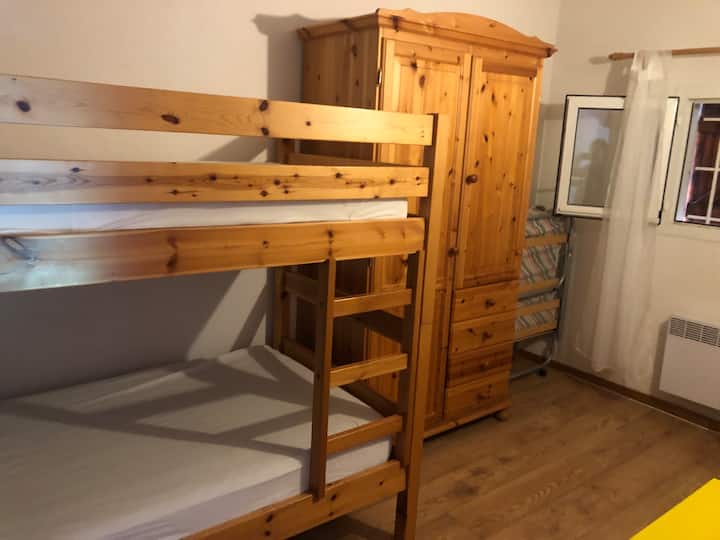 Dhomë gjumi në katin e sipërm me krevate marinarë dhe një krevat të palosshëm.