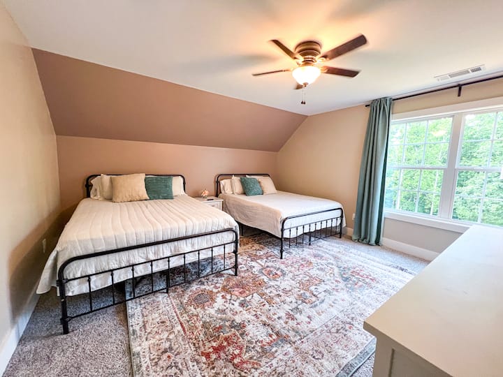 واحدة من غرفتي نوم في الطابق العلوي، تحتوي هذه الغرفة على سريرين كبيرين - مثالية للعائلات أو الأشقاء أو مساحة للتمدد!