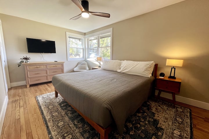 King bedroom with Smart TV and bedside lamps.