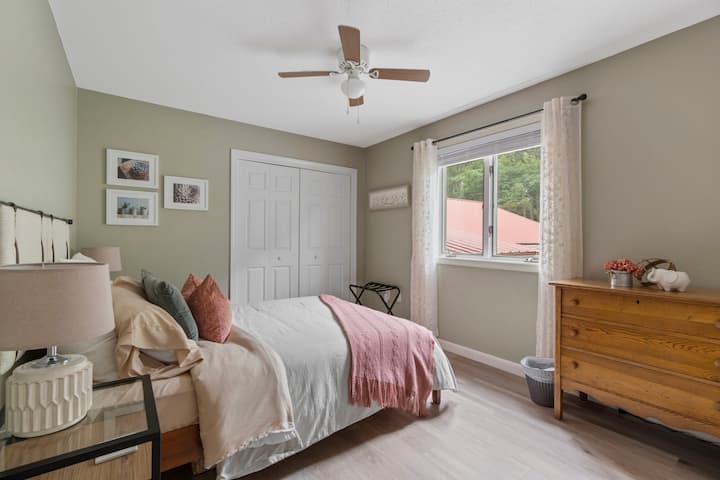Bedroom 2: Queen bed with ceiling fan and portable fan, closet and dresser.