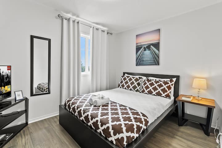 Spálňa s manželskou posteľou a 60-palcovou inteligentnou televíziou.