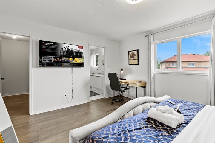 Hlavná spálňa s manželskou posteľou King, 60-palcovou inteligentnou televíziou, študijnou stanicou a vlastnou kúpeľňou.