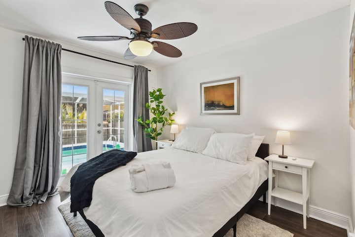 2号卧室设有通往泳池的法式门、标准双人泡沫床、衣柜和40英寸智能电视（ Netflix、Hulu、Disney + ）