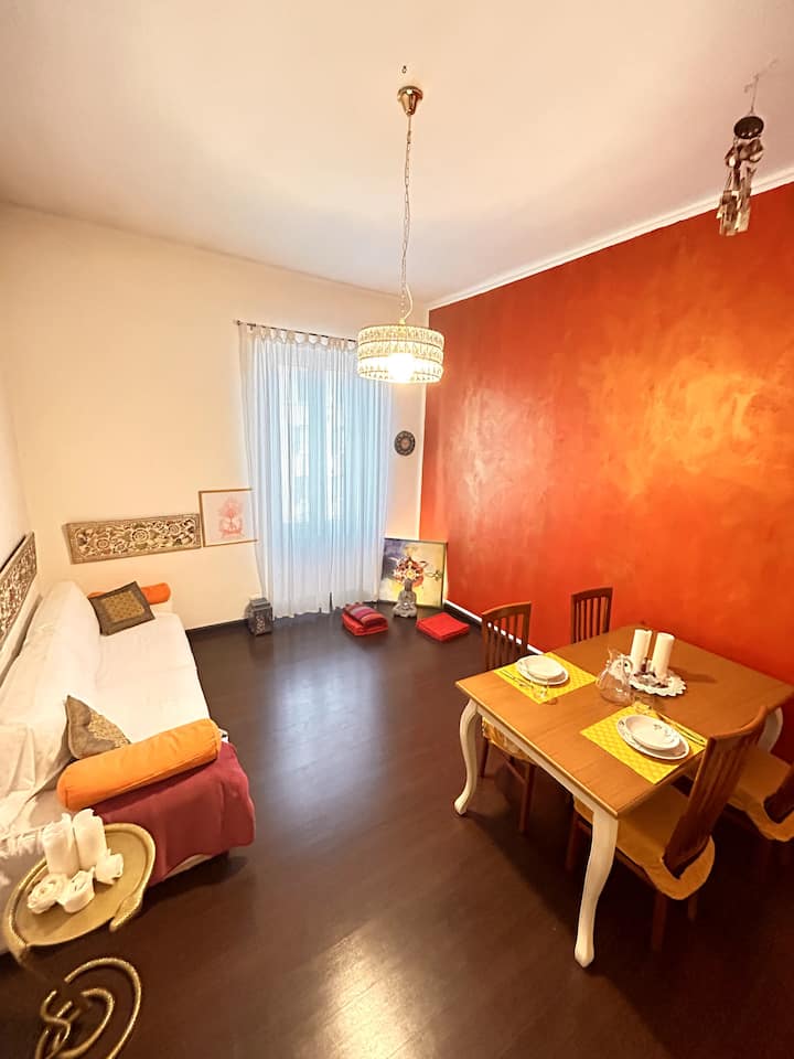 غرفة معيشة مع سرير أريكة مزدوج وطاولة تتسع لـ 6 أشخاص.