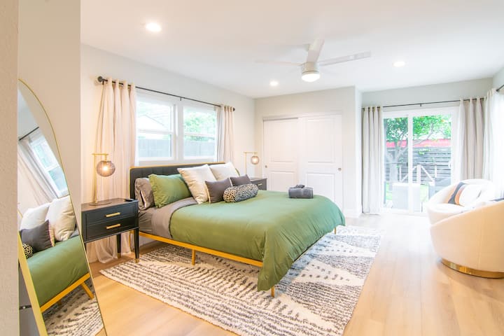 Master bedroom includes king bed, en-suite bathroom with dual vanity, smart TV, and deck access. 