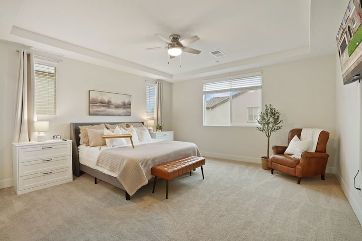 Master bedroom with a king size bed and a TV mounted on the wall. 
