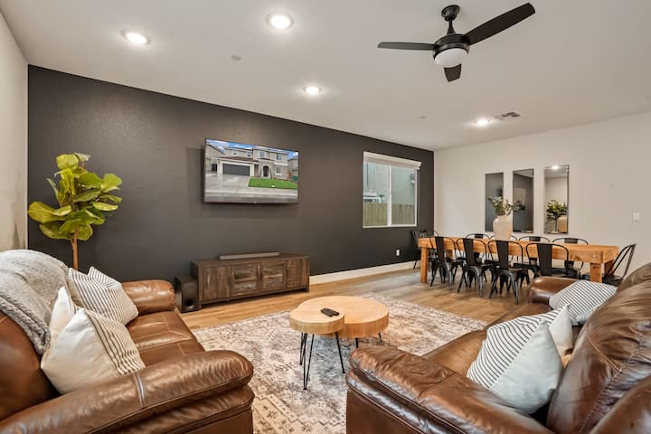 Large open living spaces. Living room with leather couches and 65 inch TV. 