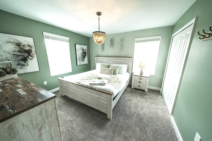 Encuentra serenidad en nuestro espacioso dormitorio adornado con una cama tamaño king, envuelto en tonos verdes relajantes y acentuado con una decoración blanca fresca, que ofrece un refugio tranquilo para una estancia rejuvenecedora.
