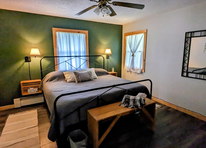 La chambre dispose d'un lit king size avec des draps moelleux, de lampes à intensité variable pour une atmosphère chaleureuse et d'une machine à bruit blanc pour plus de tranquillité, créant un espace reposant pour se détendre.