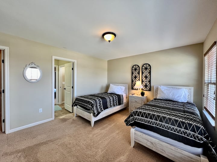 Aquí está el dormitorio número 4 ubicado en el segundo nivel de la casa. Con 2 camas individuales, un televisor grande, un armario espacioso y un baño compartido. 