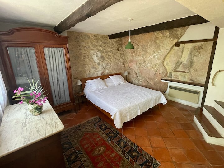 Ground floor bedroom with large double bed, real fireplace, as well as windows and door to exterior.