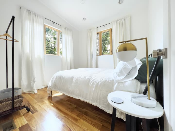 Cama tamaño queen con acogedor edredón, esta habitación tiene vistas a las montañas con el monte Pisgah a lo lejos.