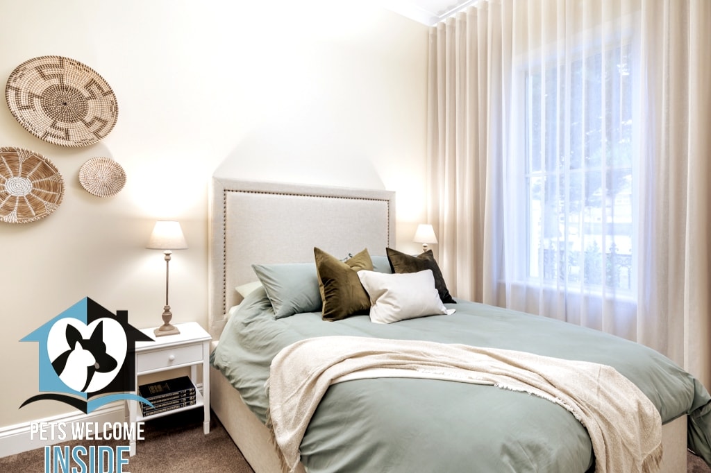 Each of the 3 beautiful bedrooms has a distinct colour theme – this one a sage green, with beds freshly made for guest arrival with sheets, pillowcases, and quilt covers.