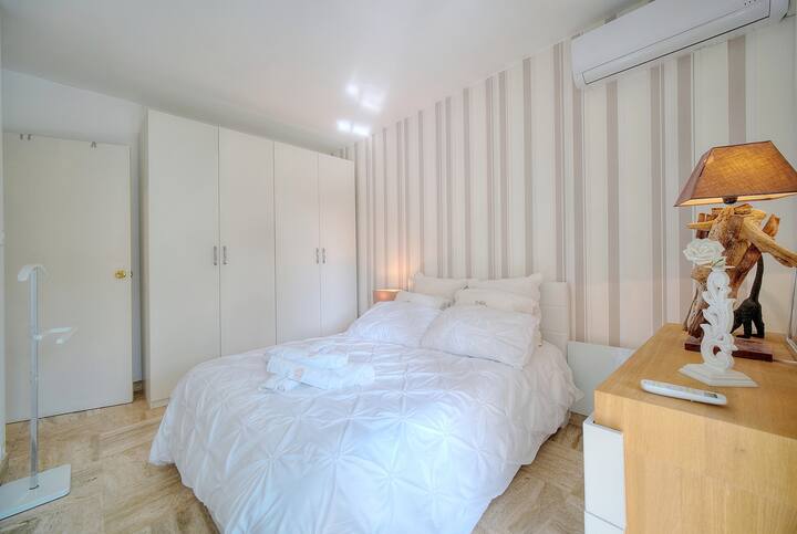 Une chambre paisible avec lit double et rangements spacieux. Profitez de la climatisation pour une nuit de sommeil paisible, idéale après une journée bien remplie à explorer la ville.