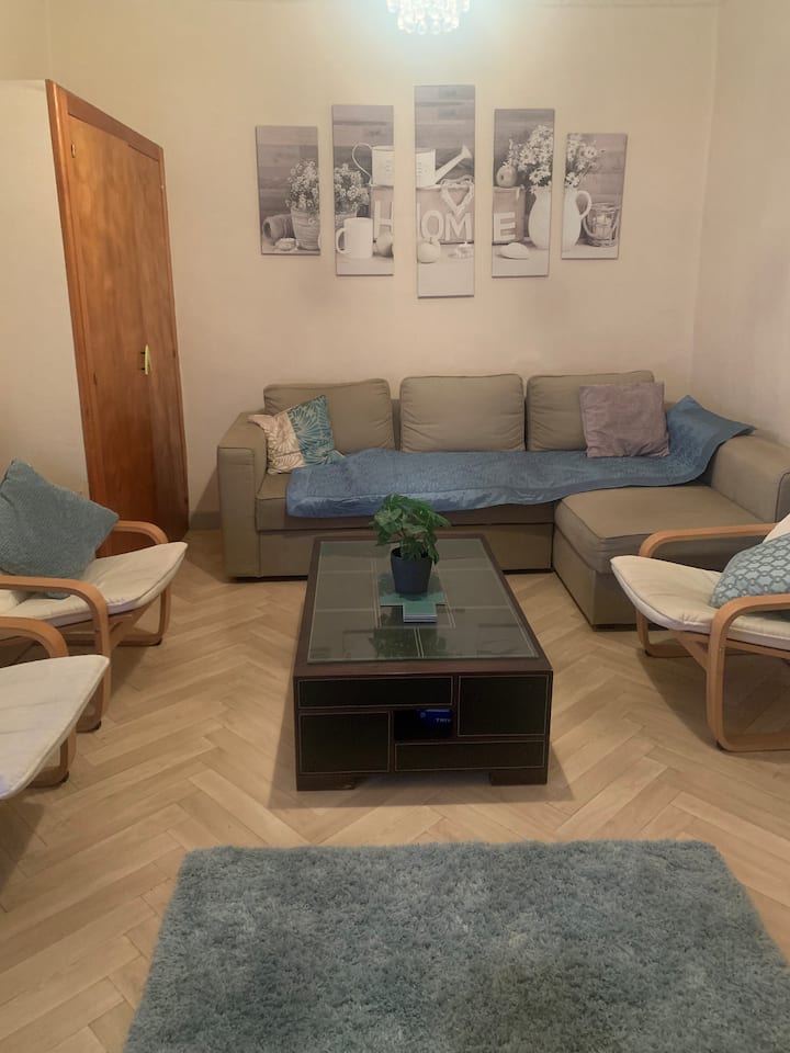 Eneo la kupumzikia lenye kitanda cha sofa mbili na runinga. Orange livebox na Wi-Fi.