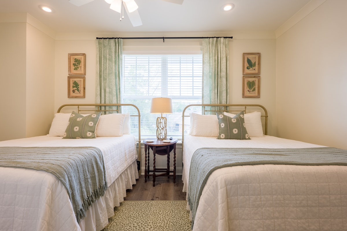 Gostinjska soba s dva bračna kreveta i Sealy Postureprdic Plus Hybrid madracima i lijepim plahtama.  U ovoj sobi nalazi se i TV ravnog ekrana.