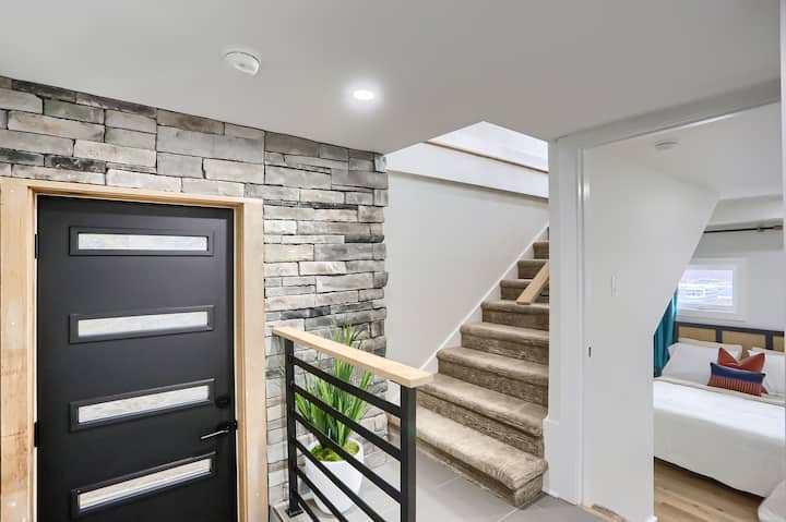 Mlango wa sehemu ya chini ya nyumba ambayo ina chumba kimoja cha kulala kilicho na vitanda 2 vya ukubwa kamili na bafu moja. Ngazi zinakuelekeza hadi sebuleni kwenye ghorofa kuu.