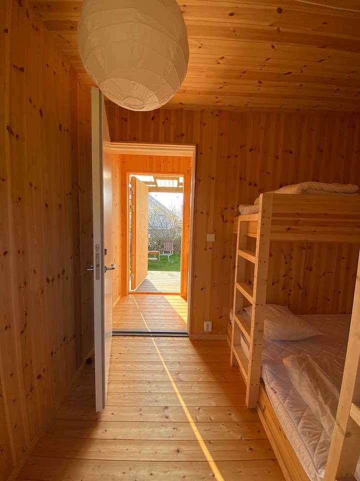 El cuarto de invitados Tower house house está conectado con el edificio principal a través del porche.  En el berso adyacente se puede disfrutar del fragante cricket y de la primera carrera de manzanas del verano.