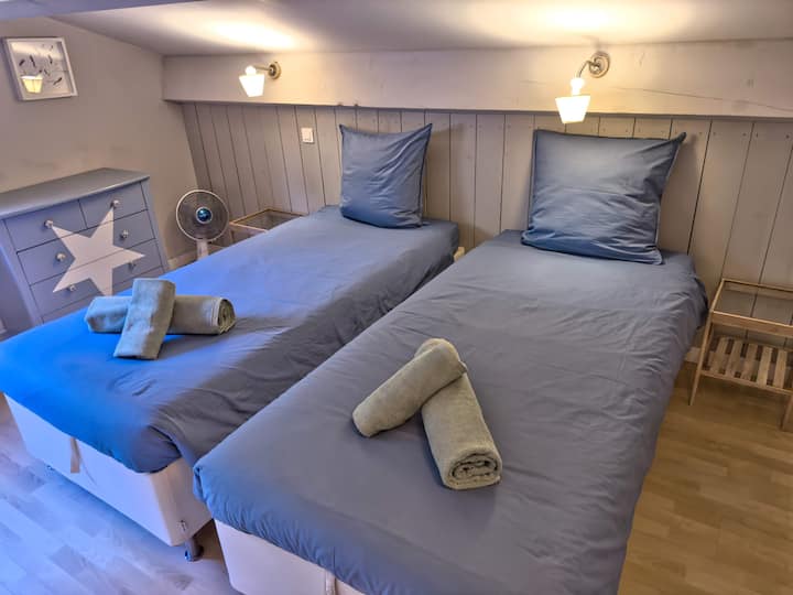 Habitación equipada con dos camas individuales cómodas y una cama supletoria, ideal para los niños.   