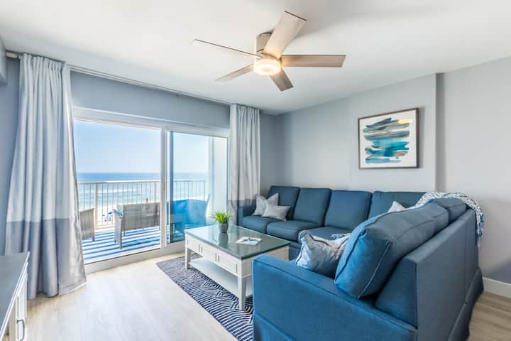 Open concept living area adjacent to private balcony with views of beach and ocean and sounds of crashing waves
