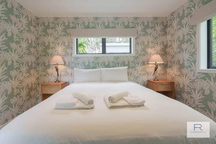 غرفة نوم بحجم كوين في الطابق السفلي مع خزانة ملابس مزدوجة.