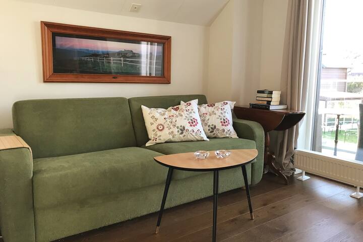 Sala de estar en el segundo piso con sofá cama (colchón de 160 cm) y un balcón con dos sillas y una mesa