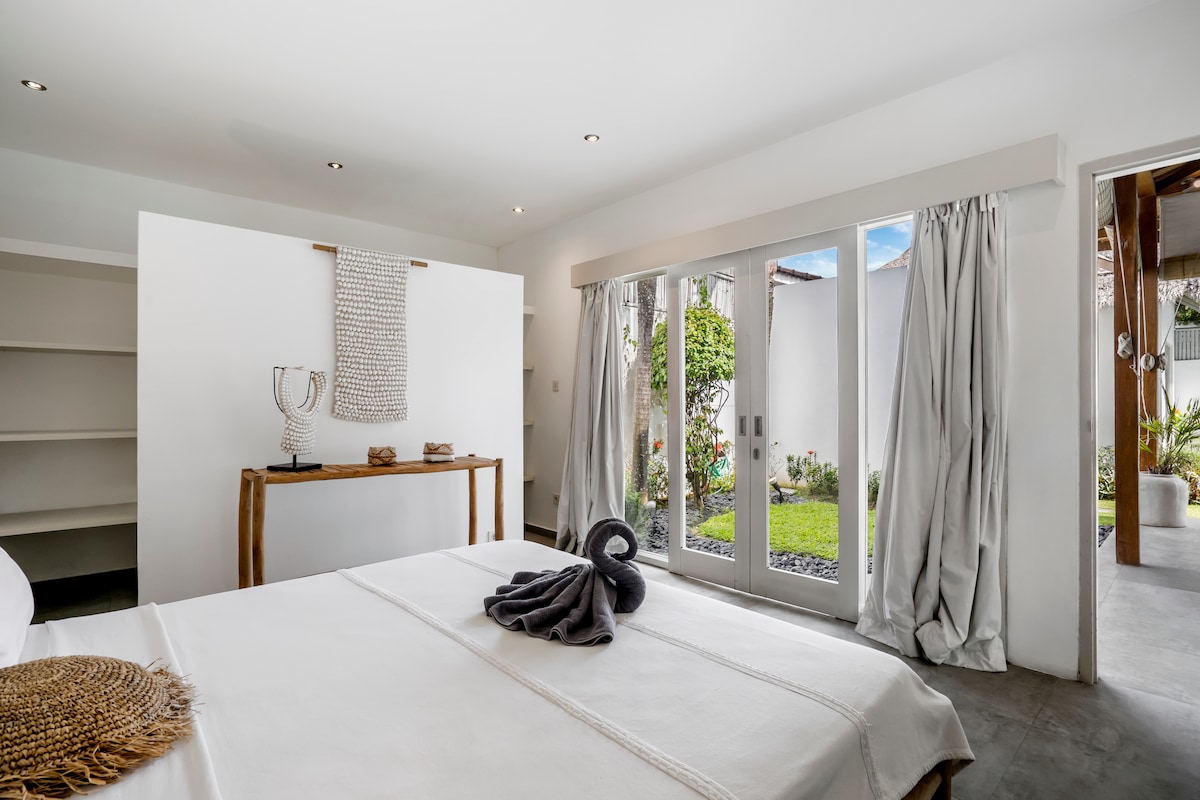 פינות נעימות וגוונים רכים הופכים את חדר השינה בווילה הזו לחלום