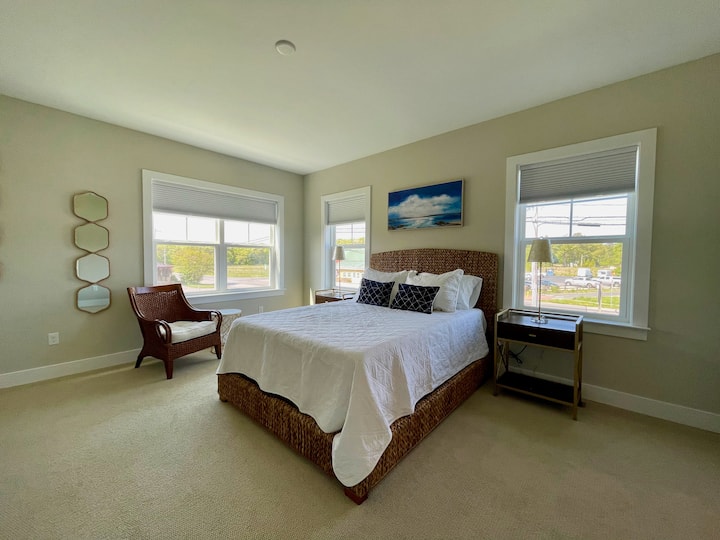 غرفة نوم أساسية في الطابق الثاني بسرير بحجم كوين وحمام داخلي وخزانة ملابس وإطلالة على الممر. 