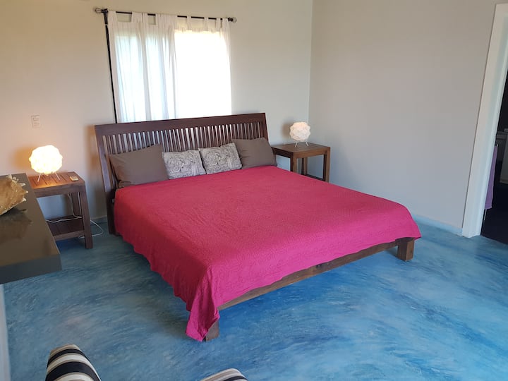 Простор: пространа спална соба со брачни кревети и едноставен декор.

