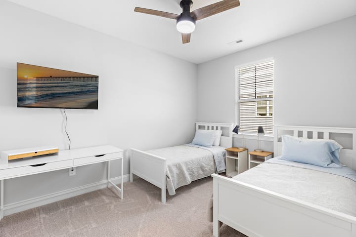 Two twin sized beds and desk in this 3rd bedroom