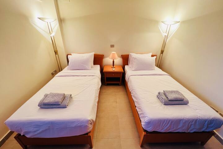 Chambre avec lits jumeaux climatisée très confortable avec 2 lits simples, matelas neufs, linge de lit et une armoire avec beaucoup de rangement.