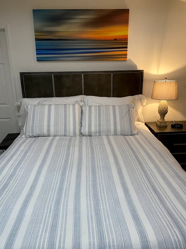 جرب رفاهية النوم المطلقة في سرير Mango Wood بحجم كوين مع مرتبة Tempur - Pedic جديدة تمامًا وملاءات نظيفة. مزينة بأعمال فنية محلية، غرفة نومنا هي واحة شخصية من الراحة والأناقة.